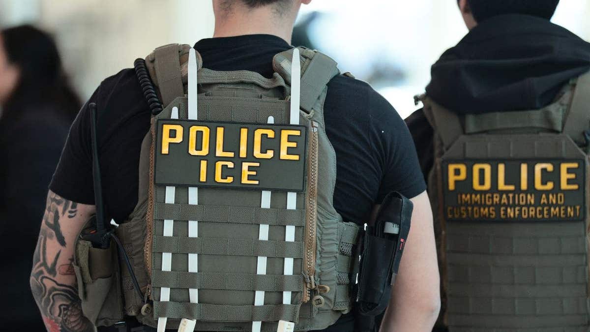 Backs of Immigration and Customs Enforcement agents as they walk