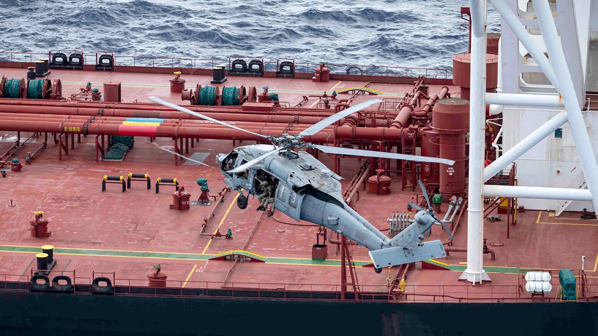 A helicopter lands on the Veronica III vessel at sea.