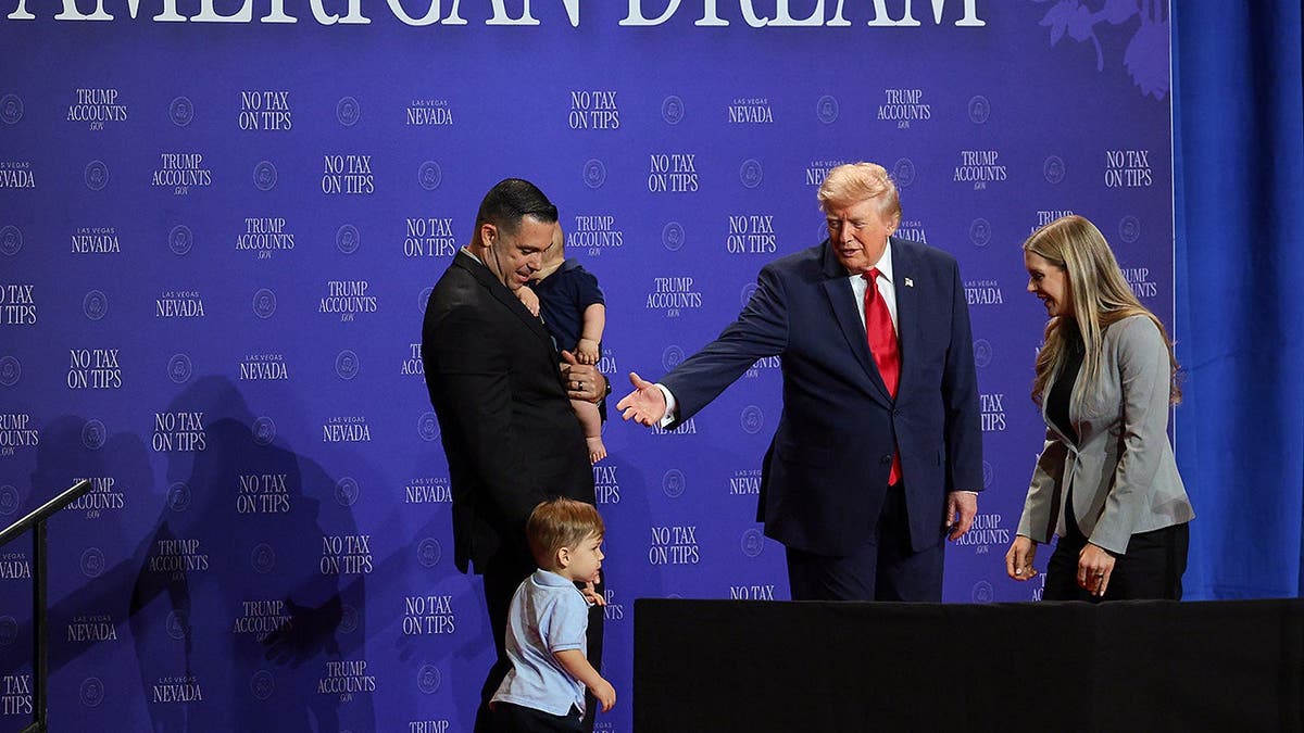 Donald Trump introduces a family onstage at Red Rock Casino Resort and Spa in Las Vegas.