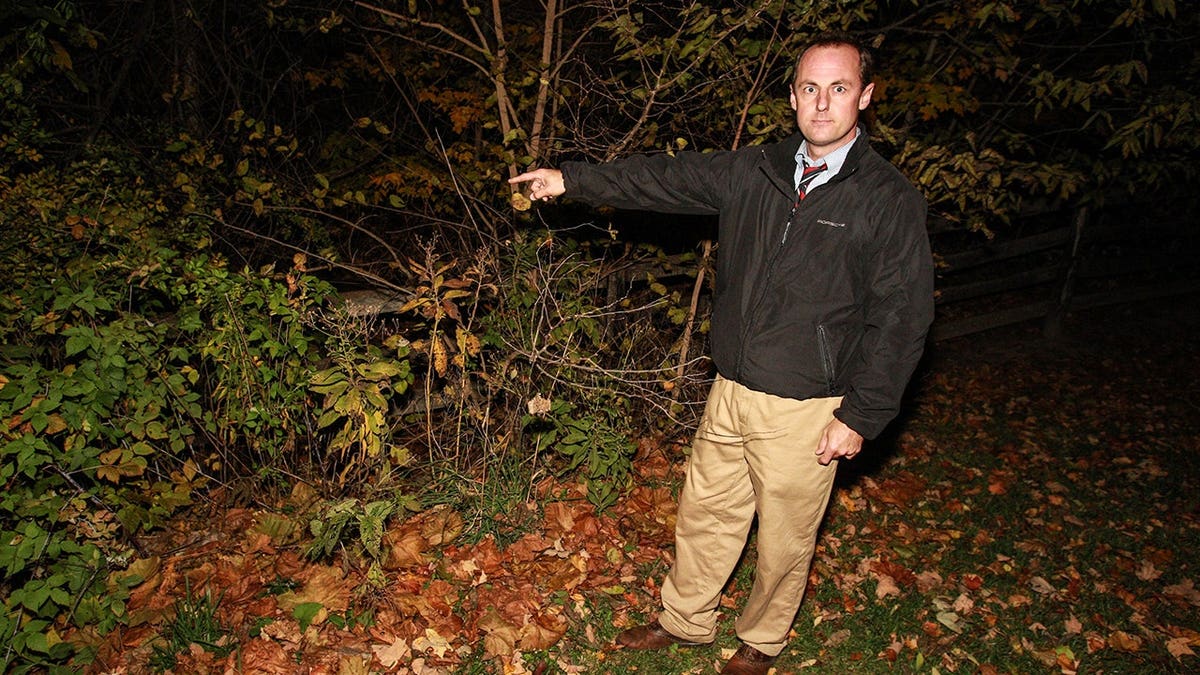 Rob Graves points toward woods behind his home at Fox Hollow Farm.