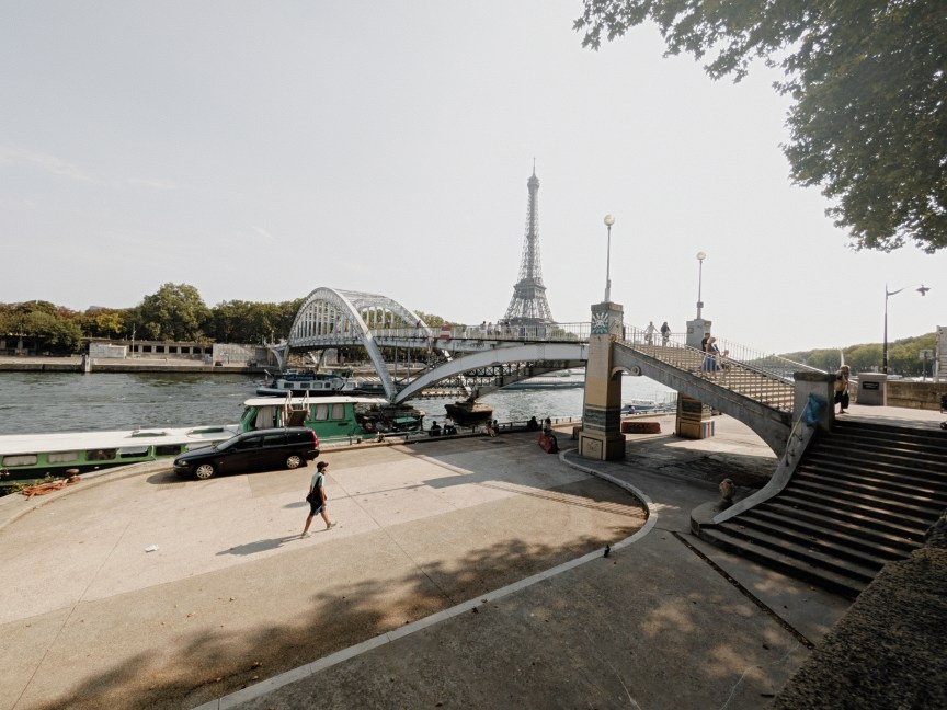 Image of a man walking next to a bridge