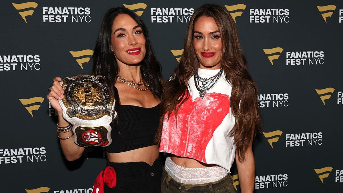 Brie Bella and Nikki Bella stand together at Fanatics Fest NYC 2026.
