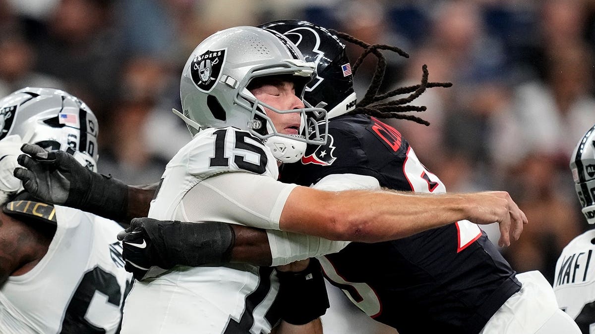 Fernando Mendoza is hit by Jadeveon Clowney during an NFL preseason game.