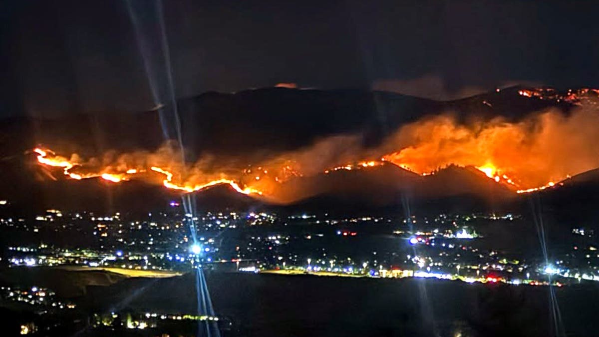 fire spreading in hills outside residential neighborhood