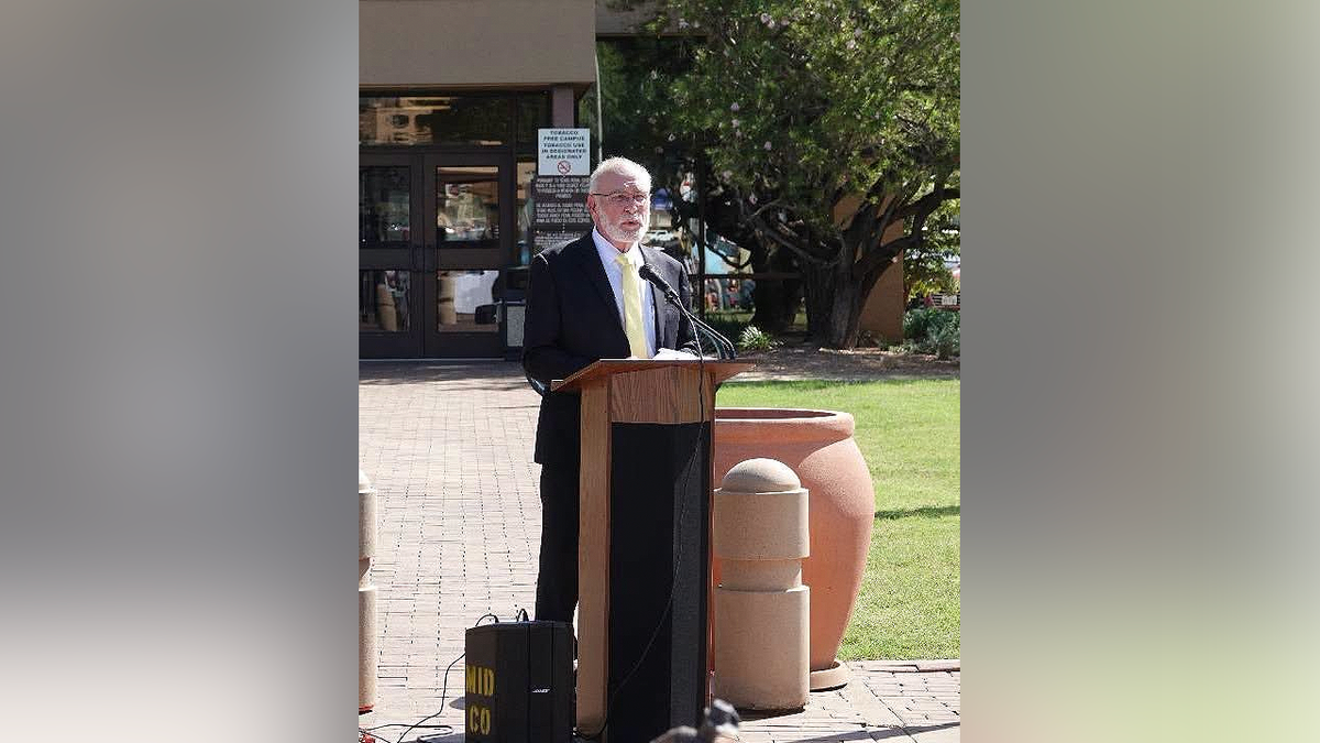 Midland County Judge Terry Johnson speaks at a podium outside a government building in Midland, Texas