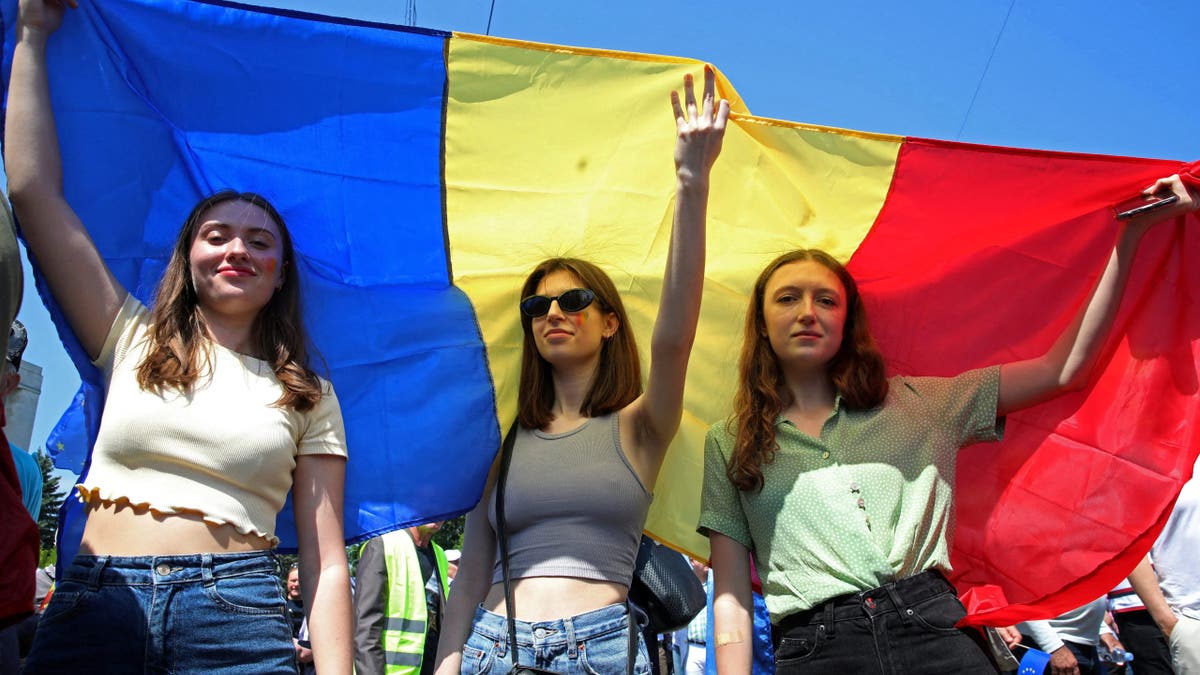 Women hold a Moldovan flag during a rally to support a European path for the country, in Chisinau, Moldova, May 21, 2023.