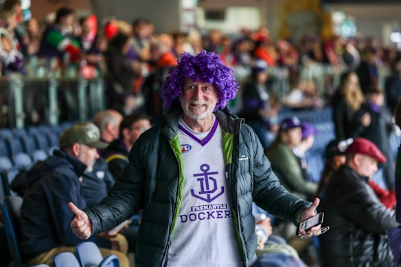 Supporters settle in before the start of the game in soggy conditions at the MCG.