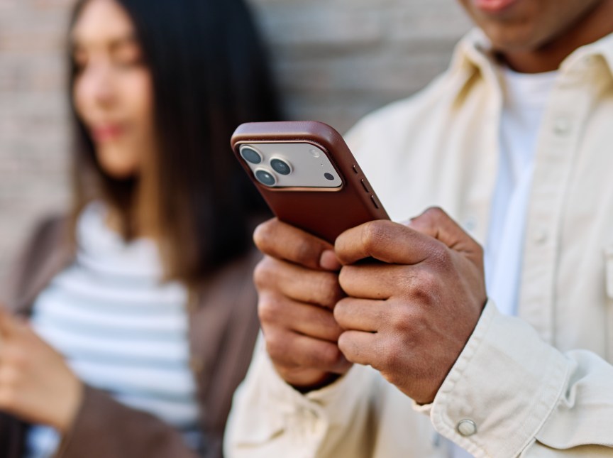 A couple looking at their iPhones.