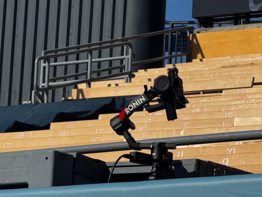 A gimbal setup mounted on the outfield wall, set up to rotate and capture players reaching over the wall to steal home runs and then quickly rotate around for fan reactions.