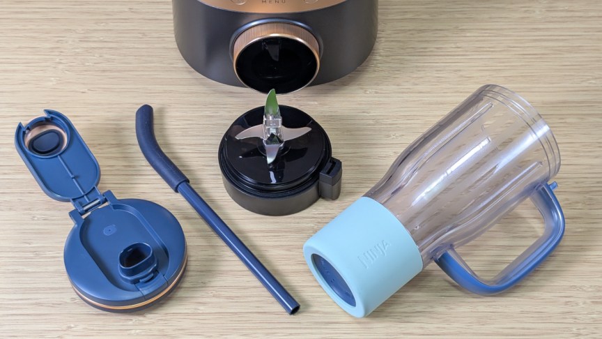Ninja-CrushBoss-Smoothie-Tumbler-with-accessories-and-blender-assembly-on-desk