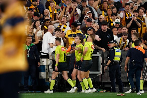 Umpires dodge projectiles as they exit the ground.