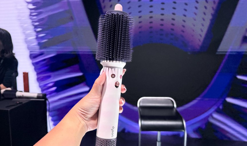 A hand holding the Dyson Airsmooth dryer brush.