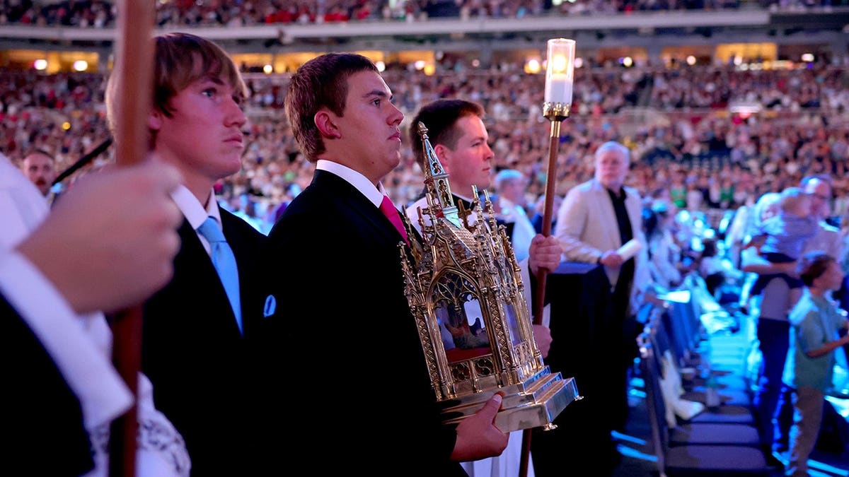 James Engstrom, 16, and his mother Bonnie carry a reliquary during Archbishop Fulton Sheen's beatification ceremony in St. Louis.