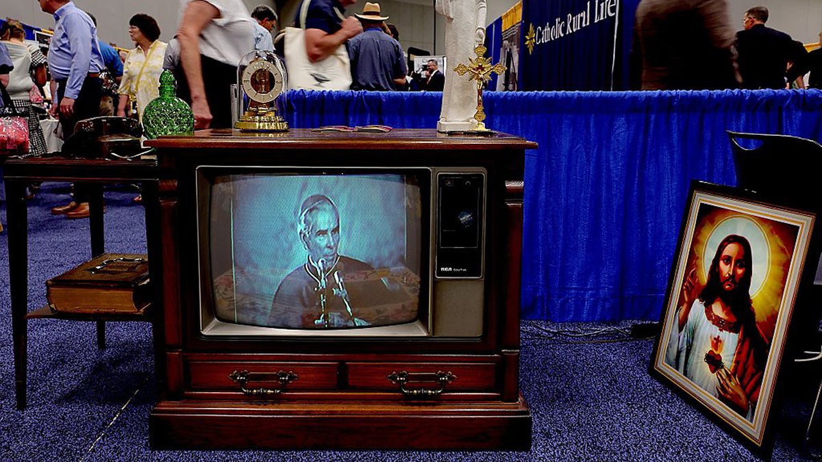 An old console TV plays an Archbishop Fulton Sheen 