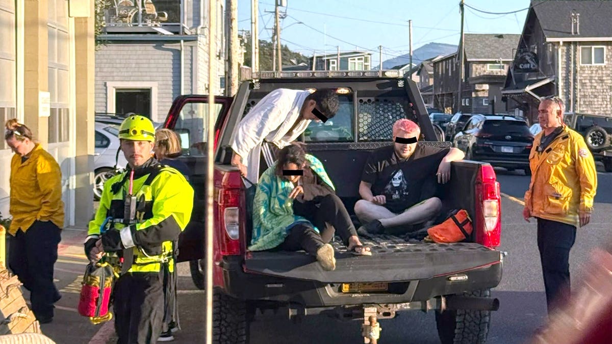 three rescued thrill-seekers in the back of a fire department pickup truck