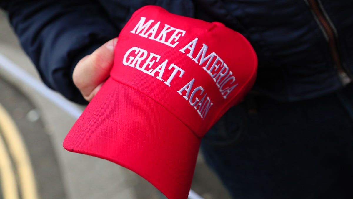 A man holds a MAGA hat as demonstrators march from BBC Broadcasting House to Downing Street in London.