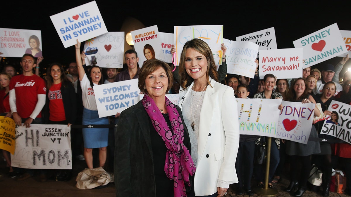 Savannah Guthrie and Nancy Guthrie posing together on an outdoor set with the Sydney Opera House in the background.