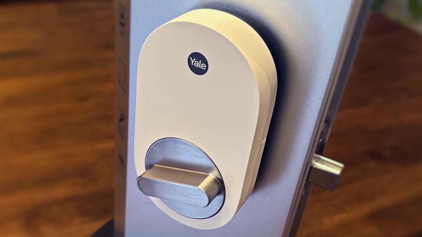 Yale's smart lock on metal testing platform on a wood table.