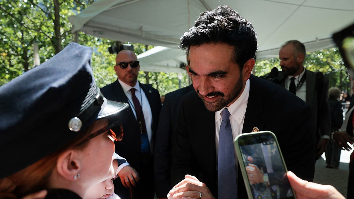 Zohran Mamdani hugs relatives of 9/11 victims during a memorial ceremony.